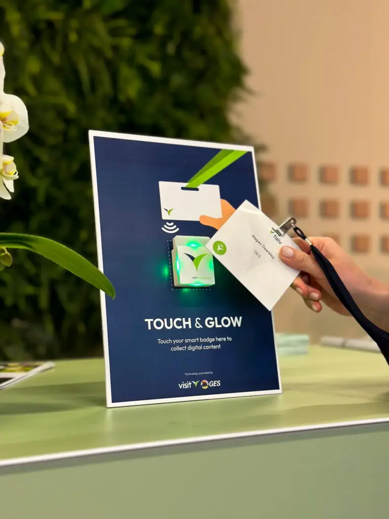Visitor tapping a smart badge on an NFC Touchpoint device at an exhibitor stand